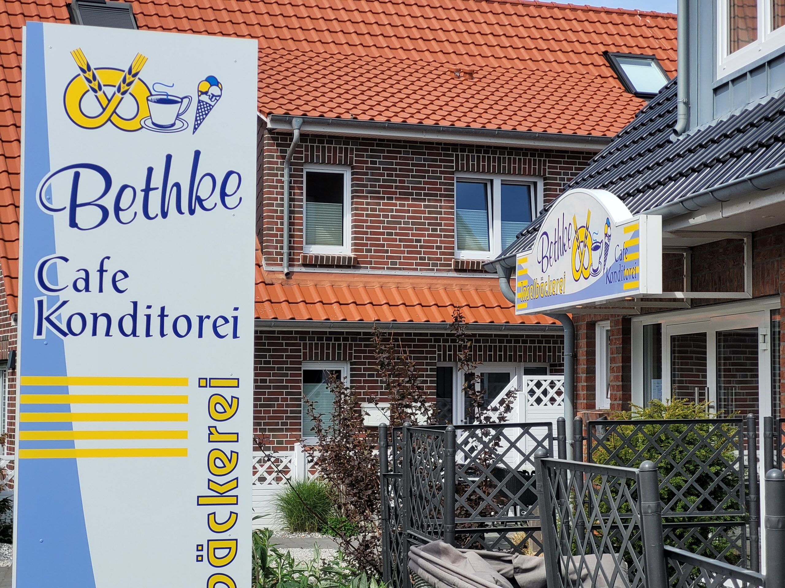 Werbestele und Gebäudeschild einer Filiale der Inselbäckerei Bethke auf Norderney (Foto von 2022)