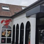 Gosch Norderney: Fischbrötchen und Sylt-Flair direkt am Kurplatz Gosch Norderney – Fassade am Kurplatz mit rotem Hummer-Logo und Plakat „Hier gibt's knackige Fischbrötchen!“