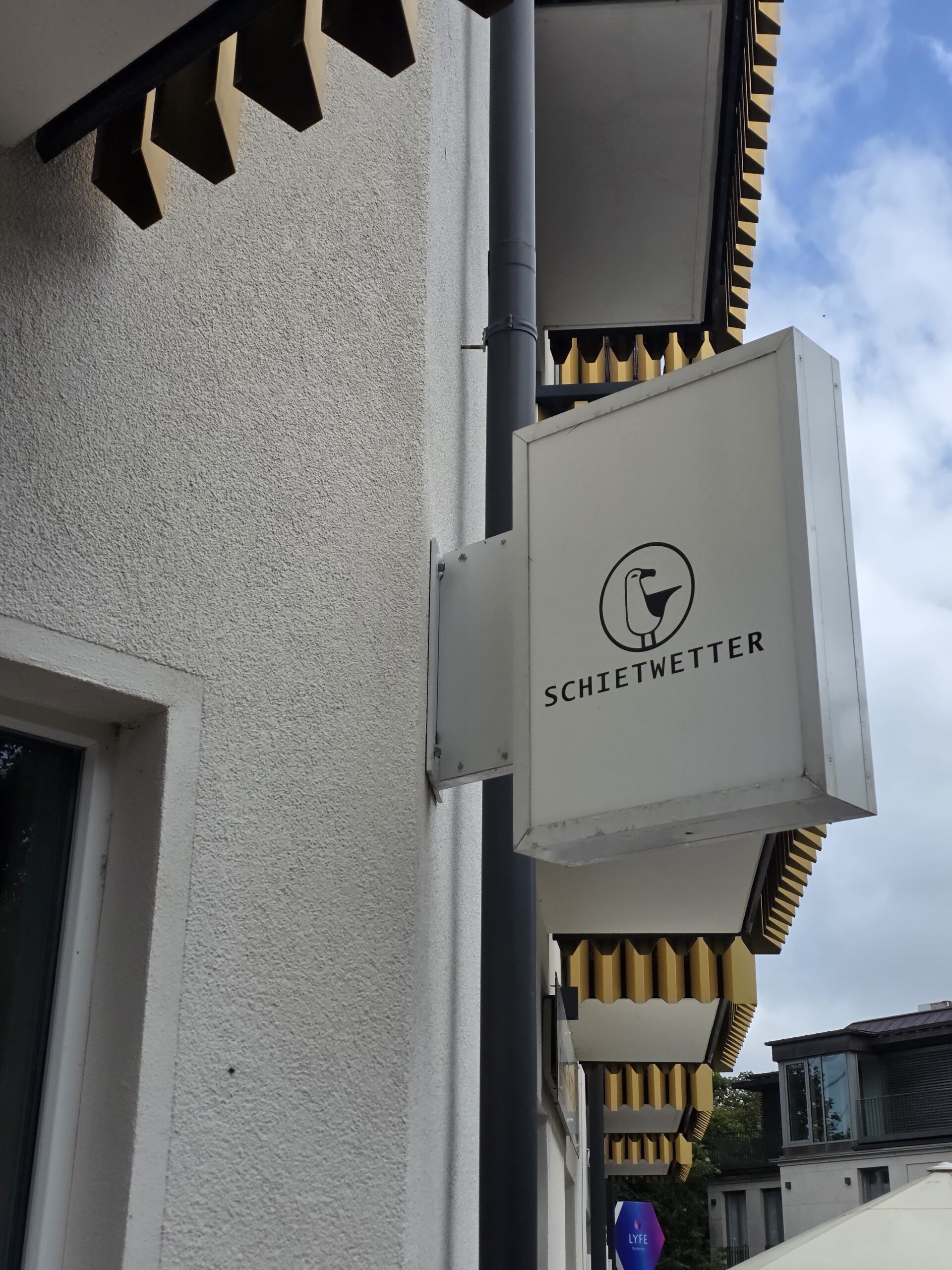 Auslegerschild mit Schietwetter-Schriftzug und Möwe
