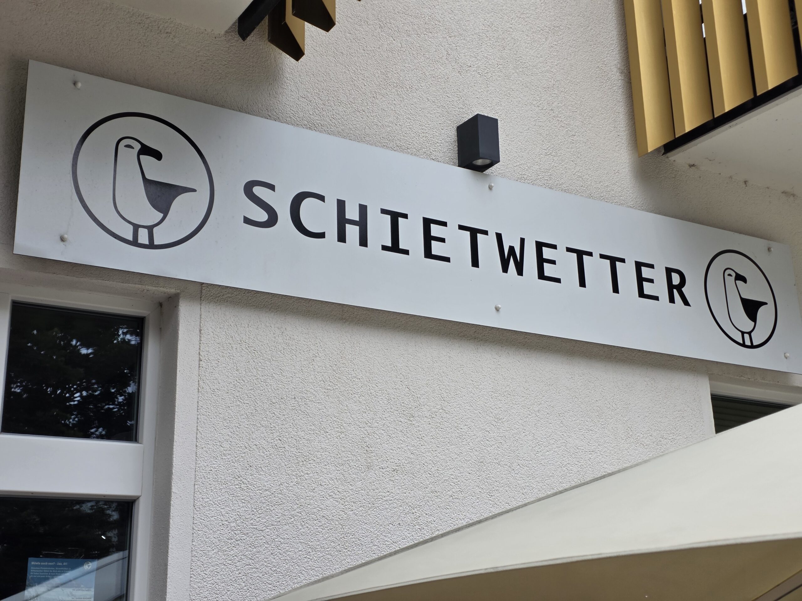 Fassadenschild mit dem Möwen-Logo von Schietwetter