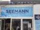 Seemann Fischspezialität in der Poststraße auf Norderney – Ladenfront mit Wellen-Logo, Anker-Emblem „Since 2025“ und Speisekarte im Schaufenster