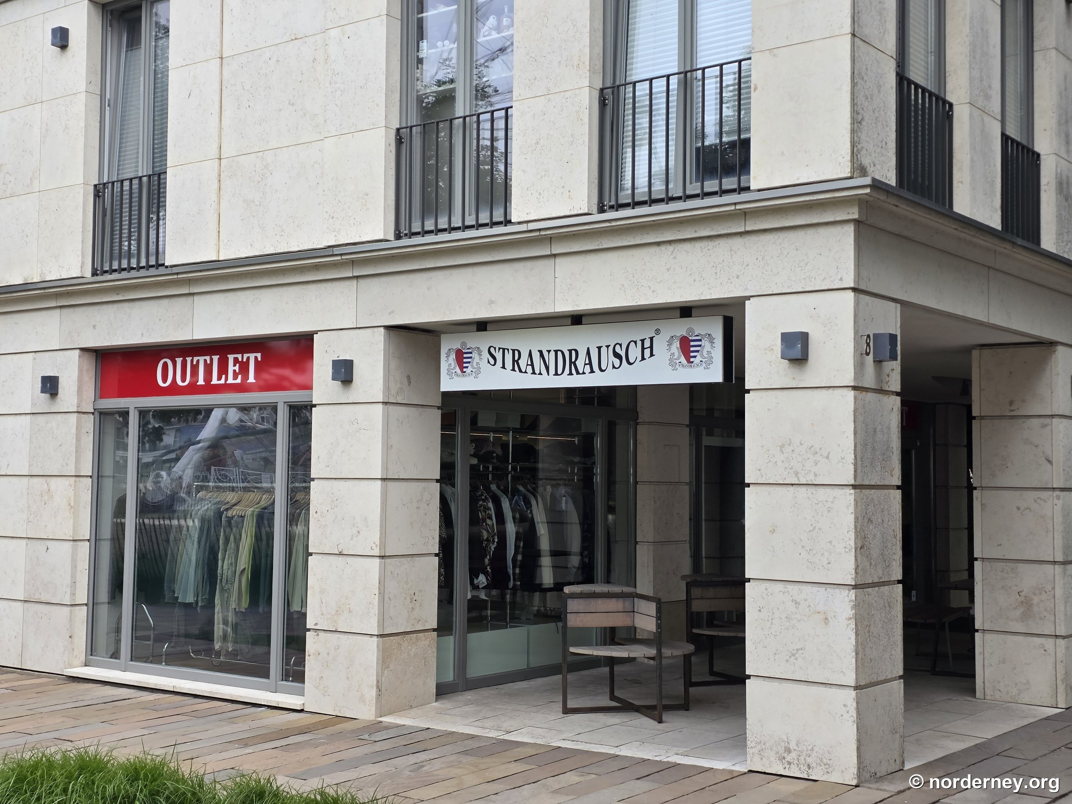 Strandrausch Outlet auf Norderney – Fassade in der Adolfsreihe 8 mit Wappen-Logo, Schriftzug STRANDRAUSCH und rotem OUTLET-Schild