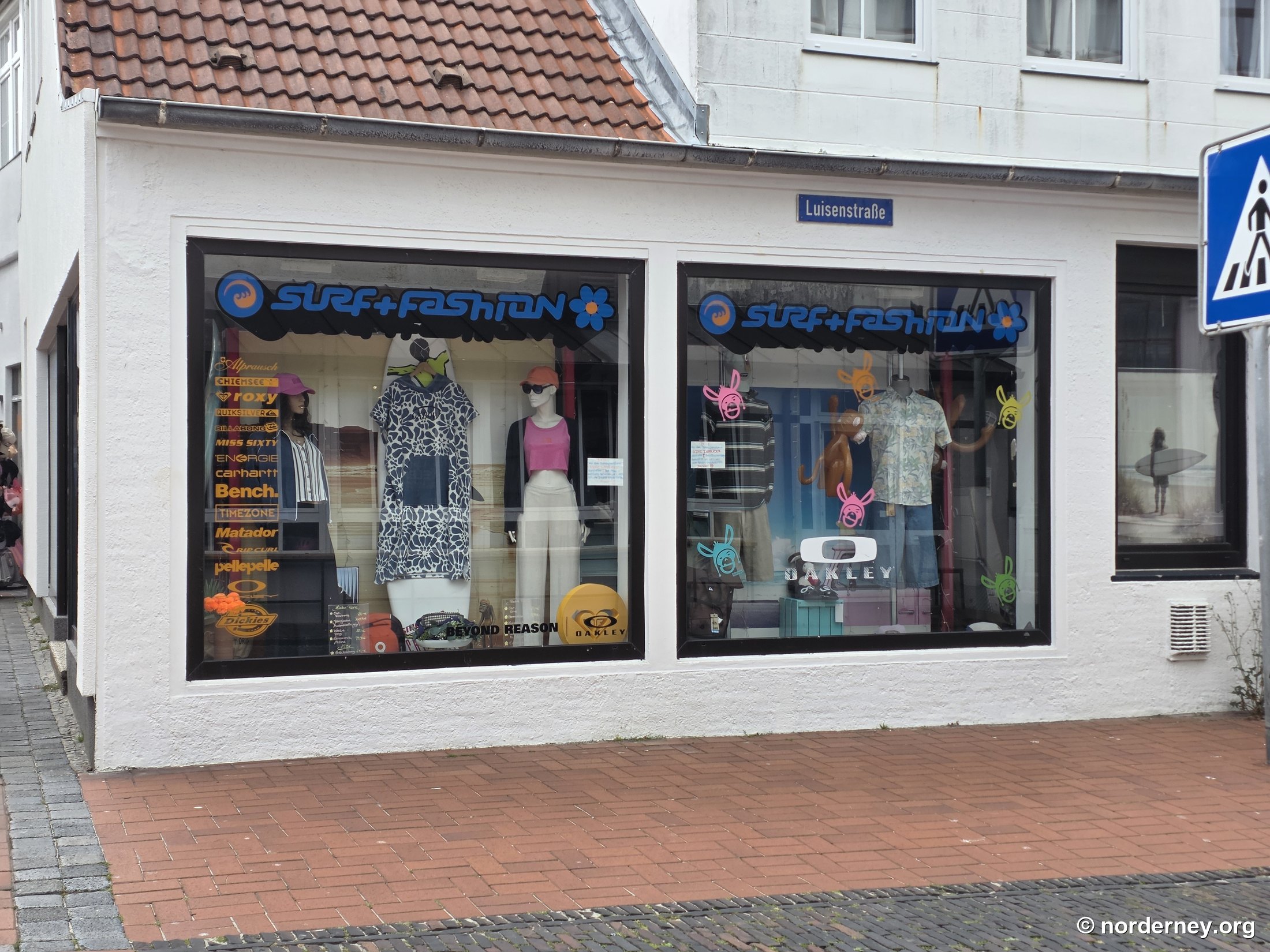 Surf + Fashion auf Norderney – Eckschaufenster in der Luisenstraße mit Surfbrettern und Marken-Logos wie Roxy, Quiksilver, Billabong, Chiemsee, Rip Curl, Carhartt und Oakley