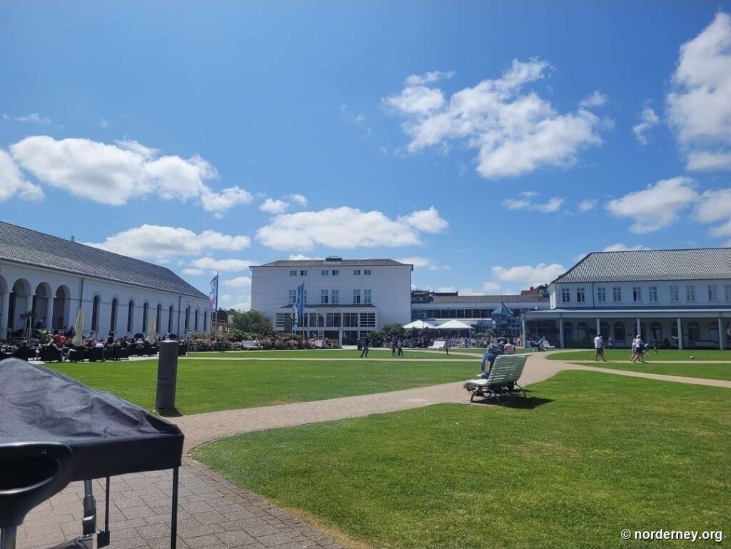 Kurplatz Norderney mit Arkaden des Conversationshauses links und dem bade:haus im Hintergrund