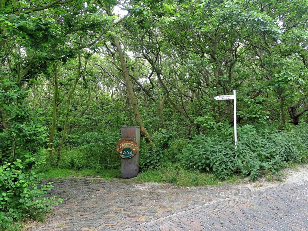 Wegweiser zum Fischerhausmuseum und Schild zum Teehuus im Argonner Wäldchen auf Norderney