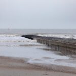 Norderney im November: Wetter, Termine und Öffnungszeiten Menschenleerer Nordstrand von Norderney mit Buhne und Brandung unter grauem Himmel