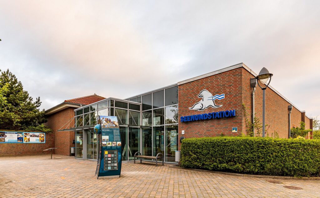 Eingang der Seehundstation Nationalpark-Haus in Norddeich mit Robben-Logo an der Backsteinfassade