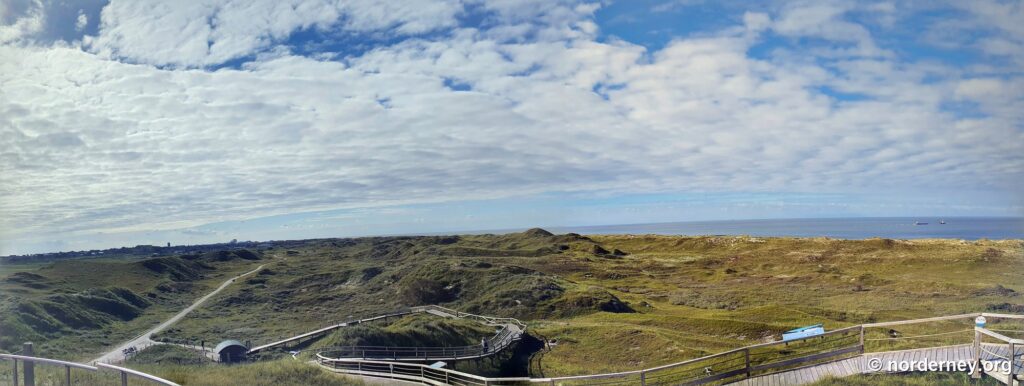 Holzstege und erhöhter Aussichtsweg in den Dünen von Norderney mit Meerblick