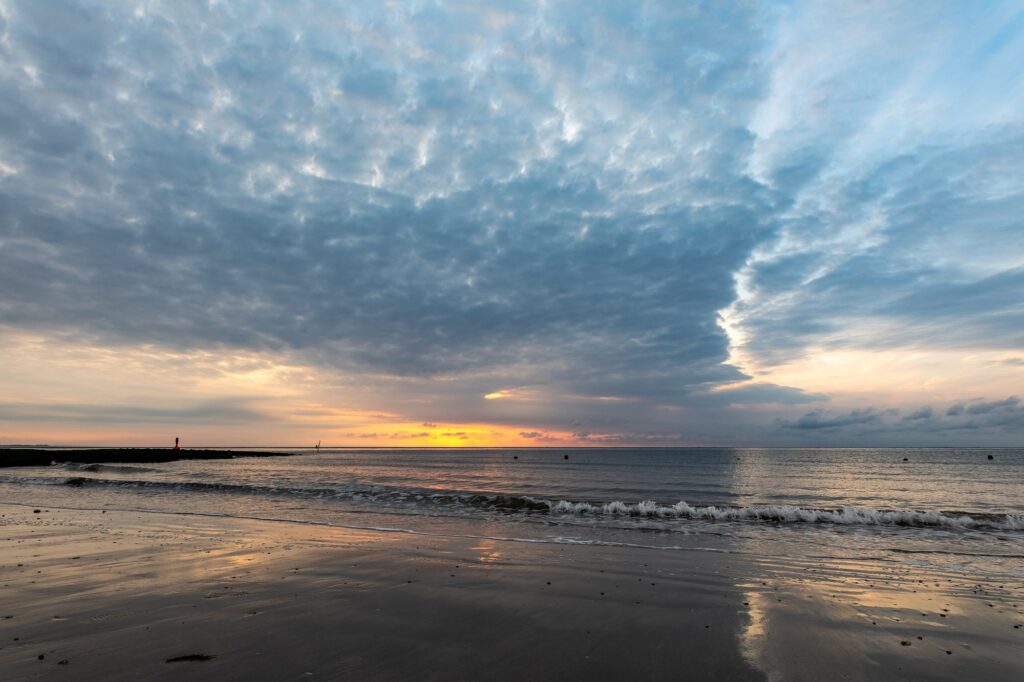 Flache Nordseewellen laufen am Abend auf den nassen Sandstrand von Norderney