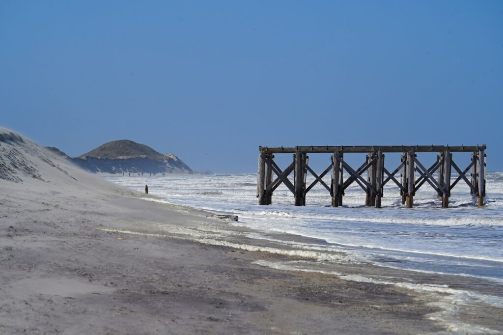 Strand an der Weißen Düne auf Norderney mit Brandung und Dünen im Hintergrund
